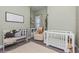 Cozy Bedroom with soft green walls, white crib, and ample natural light at 985 Huntspoint St, Winter Garden, FL 34787