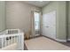 Well-lit Bedroom featuring a crib, neutral wallpaper, and coordinating window coverings at 985 Huntspoint St, Winter Garden, FL 34787