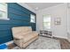 Stylish bonus room with blue accent wall, plush sofa, and modern decor at 985 Huntspoint St, Winter Garden, FL 34787