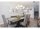 Dining room with a wooden table, chairs, chandelier, and decorations with stairs and kitchen in background at 985 Huntspoint St, Winter Garden, FL 34787