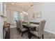 Dining room with a wooden table, chairs, chandelier, and decorations with natural light from the window at 985 Huntspoint St, Winter Garden, FL 34787