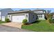 Detached two-car garage featuring carriage doors, exterior lights, and landscaped yard at 985 Huntspoint St, Winter Garden, FL 34787
