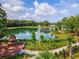 Scenic lake view with a charming pier, brick patio with fireplace, and landscaped walking path at 985 Huntspoint St, Winter Garden, FL 34787