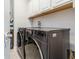 Laundry room showcasing a modern washer and dryer with storage cabinets above at 985 Huntspoint St, Winter Garden, FL 34787