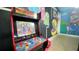 Close-up of arcade machine in game room with colorful mural background at 1001 Lester Ridge Ct, Kissimmee, FL 34747