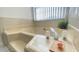 Relaxing soaking bathtub with corner window, bright tile, and bath accessories at 1001 Lester Ridge Ct, Kissimmee, FL 34747