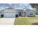 Charming single-story home with a well-manicured lawn and attached two-car garage at 1001 Lester Ridge Ct, Kissimmee, FL 34747