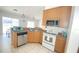 Kitchen with stainless steel appliances, light brown cabinets, and a corner sink at 1001 Lester Ridge Ct, Kissimmee, FL 34747