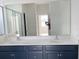 Modern bathroom features double sink vanity with a large mirror and a tiled shower at 1009 Hendon Loop, Davenport, FL 33837