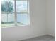 Sunlit bedroom features neutral color scheme, window view, and carpeted floor at 1009 Hendon Loop, Davenport, FL 33837