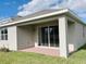 New home's covered patio with brick base overlooks a green lawn and blue sky at 1009 Hendon Loop, Davenport, FL 33837