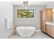 Bright bathroom with a modern soaking tub, stylish fixtures, and storage cabinet at 1018 Stetson St, Orlando, FL 32804