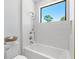 Bathroom featuring white subway tile, a soaking tub, and a large window at 1018 Stetson St, Orlando, FL 32804