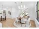 Elegant dining area featuring modern lighting, a round table with white chairs, and light wood floors at 1018 Stetson St, Orlando, FL 32804