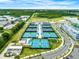 Aerial view of a community tennis court complex with meticulously maintained blue courts and lush landscaping at 1018 Stetson St, Orlando, FL 32804