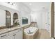Bathroom showcasing double sinks, granite countertops, and a soaking tub by the window at 1377 Tappie Toorie Cir, Lake Mary, FL 32746