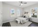 Bright bedroom featuring dark wood floors, a ceiling fan, and two arched windows with plantation shutters at 1377 Tappie Toorie Cir, Lake Mary, FL 32746