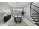 Elegant dining room featuring a modern chandelier, adjacent to staircase and large windows at 1377 Tappie Toorie Cir, Lake Mary, FL 32746