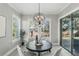 Bright dining area with round table, modern chandelier, and sliding glass doors to the outside at 1377 Tappie Toorie Cir, Lake Mary, FL 32746