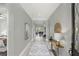 A long, well-lit hallway with white tile flooring and decorative table with mirror at 1377 Tappie Toorie Cir, Lake Mary, FL 32746