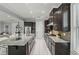 A bright kitchen with an island that has granite countertops, dark cabinets, and stainless steel appliances at 1377 Tappie Toorie Cir, Lake Mary, FL 32746