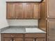 Convenient laundry area with granite counters, sink, and dark wood cabinets at 1377 Tappie Toorie Cir, Lake Mary, FL 32746