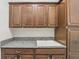 Functional laundry room with granite countertops, custom cabinets, and a utility sink at 1377 Tappie Toorie Cir, Lake Mary, FL 32746