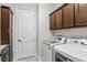 Efficient laundry room equipped with a washer, dryer, custom cabinets, and utility sink at 1377 Tappie Toorie Cir, Lake Mary, FL 32746