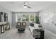 Neutral Living Room features light paint, a ceiling fan, and a view of mature landscaping at 1377 Tappie Toorie Cir, Lake Mary, FL 32746