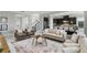Open-concept living room with modern decor, adjacent kitchen, and staircase at 1377 Tappie Toorie Cir, Lake Mary, FL 32746