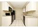 Efficient kitchen with white cabinets, black appliances, and tile flooring at 1389 Rural Hall St, Deltona, FL 32725