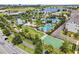 An aerial view of the community pool, landscaping, and basketball court surrounded by lush greenery and modern homes at 14137 Walcott Ave, Orlando, FL 32827