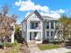 Charming two-story home featuring a double balcony, blue door, mature trees, and manicured front lawn at 14137 Walcott Ave, Orlando, FL 32827