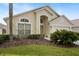 Front exterior of home featuring an arched entry, manicured landscaping, and an attached two-car garage at 155 Barefoot Beach Way, Kissimmee, FL 34746