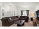 Spacious living room featuring a large sectional sofa, front door and front windows with dark curtains at 155 Barefoot Beach Way, Kissimmee, FL 34746