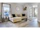 Comfortable living room featuring a plush beige sectional sofa, stylish rug, and ample natural light from a large window at 1613 N Lakewood Ave, Ocoee, FL 34761