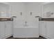 Bright bathroom featuring dual vanities, a tiled backsplash and a centered soaking tub at 17572 Davenport Rd, Winter Garden, FL 34787