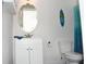 Bright bathroom featuring a white vanity, oval mirror, toilet, and charming beach-themed decor at 17572 Davenport Rd, Winter Garden, FL 34787