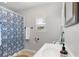 Cozy bathroom with updated vanity, shower with blue floral curtain, and natural light at 1855 Cloverlawn Ave, Orlando, FL 32806