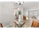 Bright dining area featuring a glass-top table with modern chandelier and stainless steel appliances nearby at 1920 E Edgewood Dr # A5, Lakeland, FL 33803
