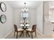 Dining room features modern light fixture, glass table, and views of the kitchen at 1920 E Edgewood Dr # A5, Lakeland, FL 33803