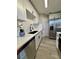 Galley kitchen features white cabinets, stainless steel appliances, and gray wood-look flooring at 1920 E Edgewood Dr # A5, Lakeland, FL 33803