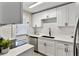 Modern kitchen features white cabinetry, stainless steel appliances, and sleek black hardware at 1920 E Edgewood Dr # A5, Lakeland, FL 33803