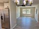 Open living room with new stainless steel refrigerator, gray walls, and a view of the front door at 1920 E Edgewood Dr # A5, Lakeland, FL 33803