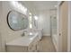 Modern bathroom with dual vanities, quartz countertops, sleek mirrors, and a glass-enclosed shower at 216 Homewood Dr, Sanford, FL 32773