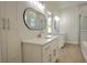 Modern bathroom with dual vanities, quartz countertops, sleek mirrors, and a glass-enclosed shower at 216 Homewood Dr, Sanford, FL 32773