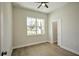 Bright bedroom featuring a large window, ceiling fan, neutral walls, and wood-look vinyl flooring at 216 Homewood Dr, Sanford, FL 32773