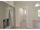 Hallway view with stainless steel refrigerator and white walls with an doorway leading to another room with natural light at 216 Homewood Dr, Sanford, FL 32773