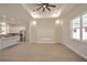 Spacious living room with tray ceiling, fan, recessed lighting, and an open layout to the kitchen area with white cabinets at 216 Homewood Dr, Sanford, FL 32773