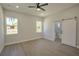 Spacious main bedroom with sliding barn door leading to main bathroom, ceiling fan and recessed lighting and windows at 216 Homewood Dr, Sanford, FL 32773